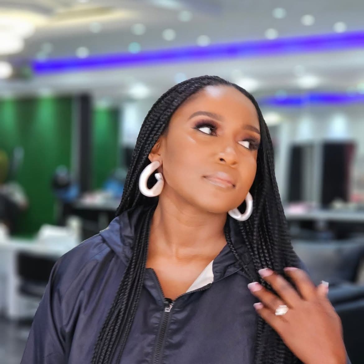 Modern evening glam with bold silver hoops, defined eyes, and long braided hair
