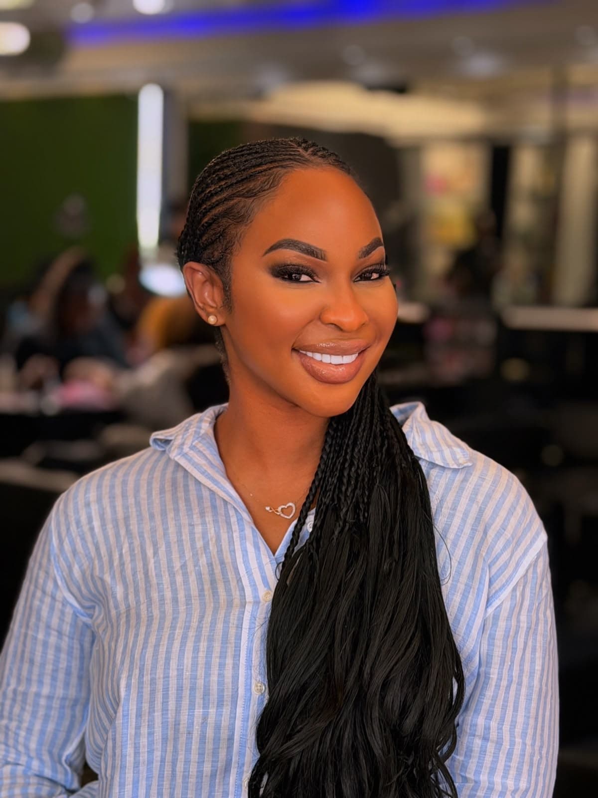 Refined soft glam with glossy nude lip and voluminous micro braids in striped studio shirt