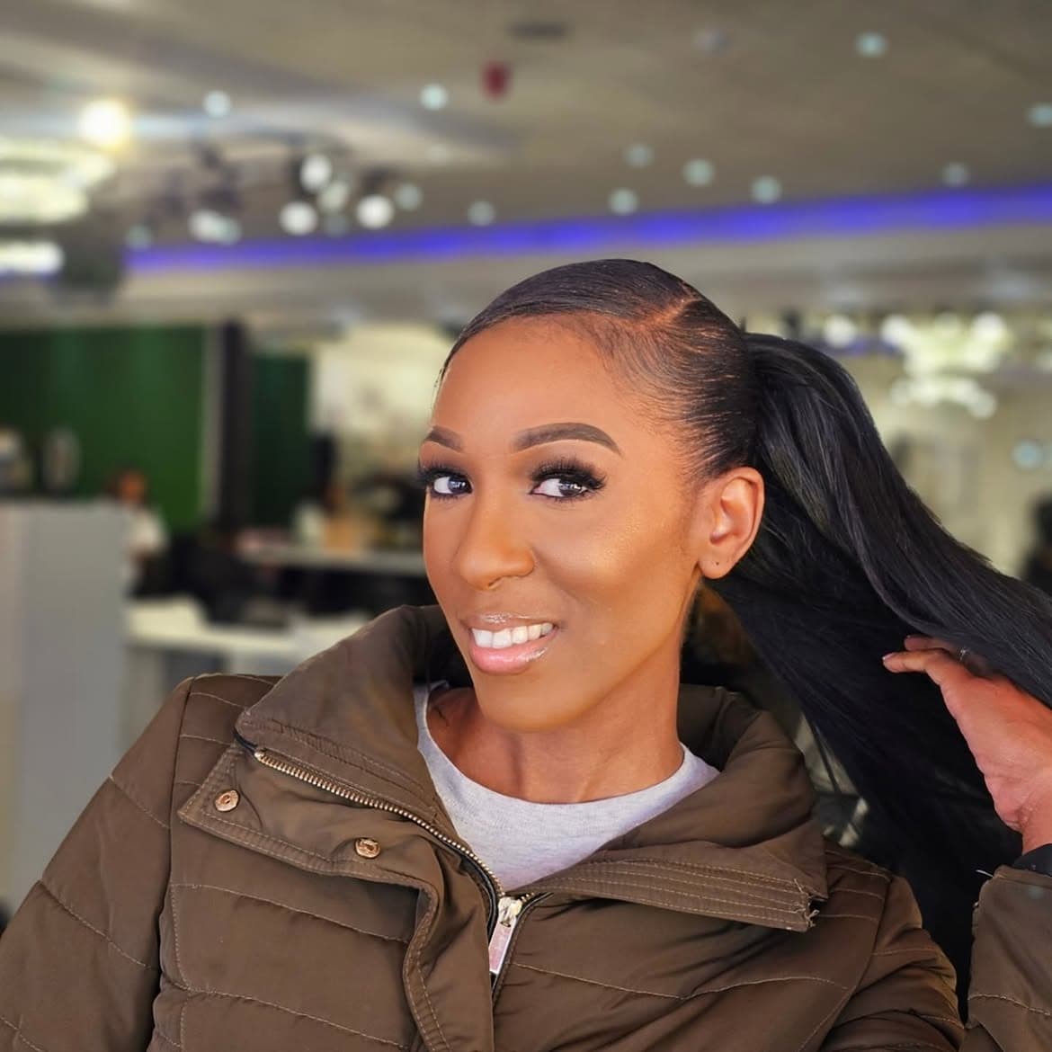Warm golden cheek glow with snatched high ponytail and puffer jacket