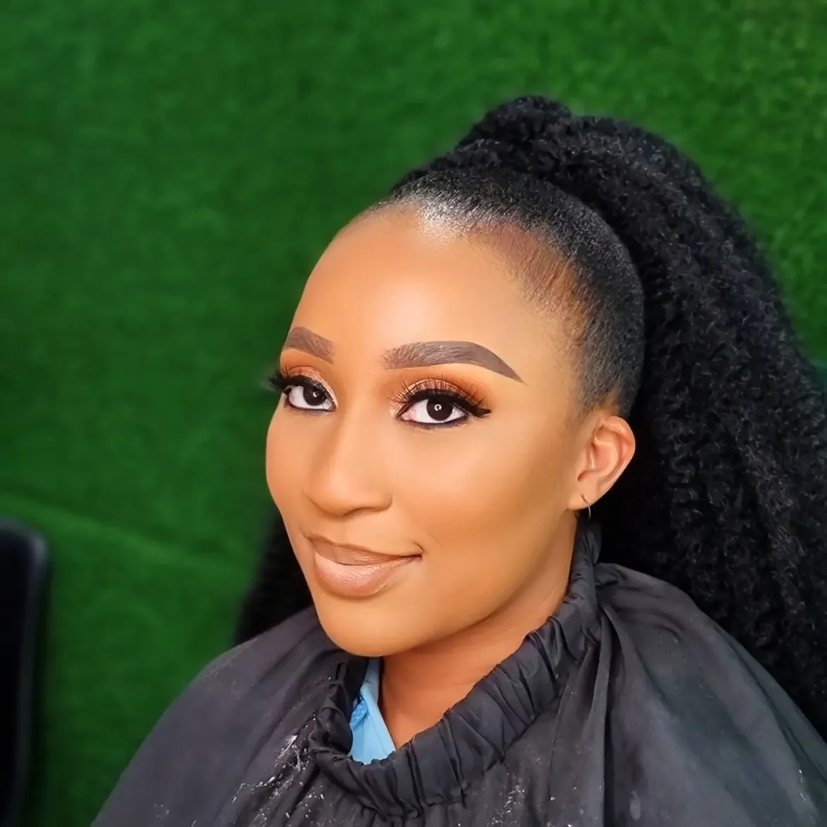 Natural golden hour glow with soft winged liner, nude lips, and braided ponytail