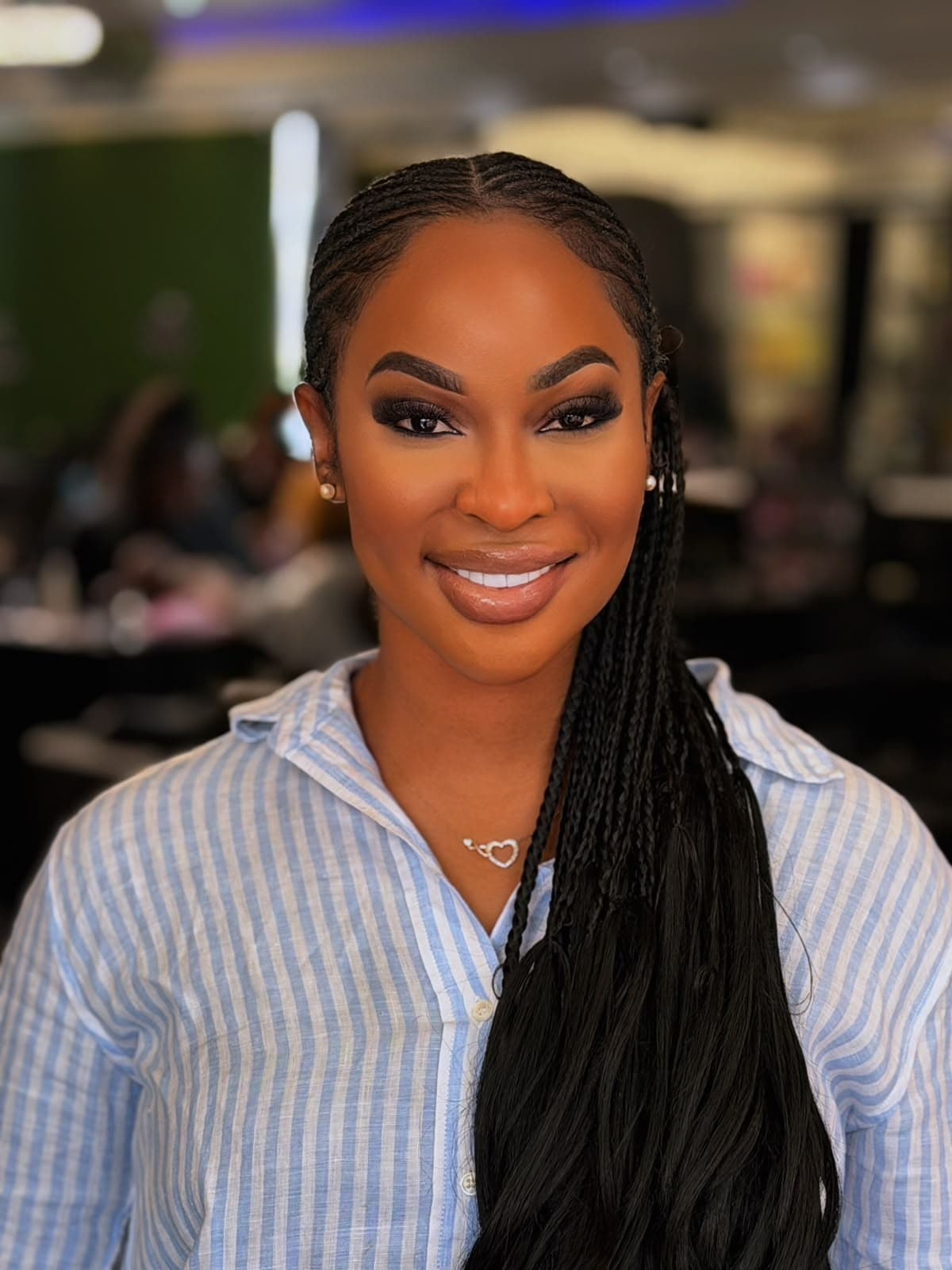 Bukky Anny signature glam artistry with radiant skin, micro braids, and luminous smile